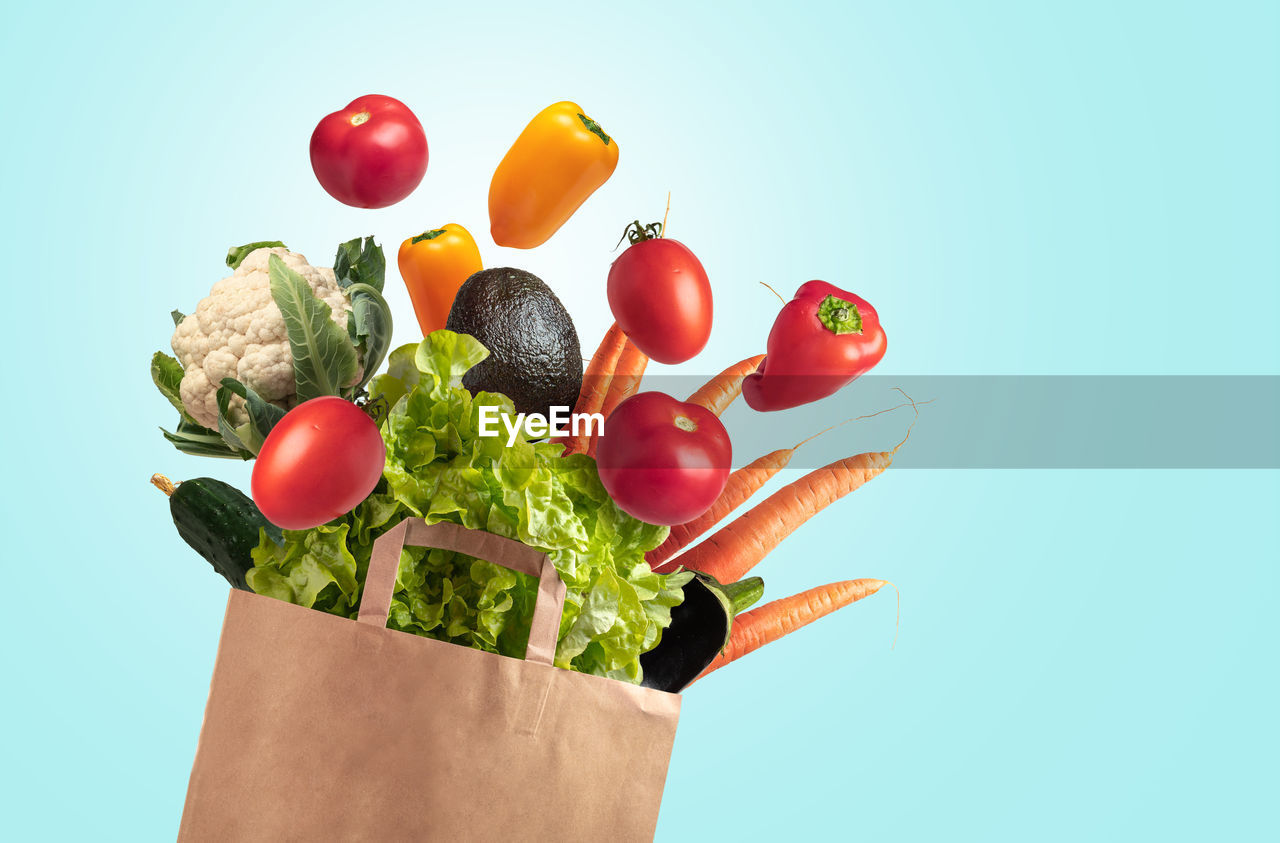Recyclable bag of fresh vegetables on blue summer sky background