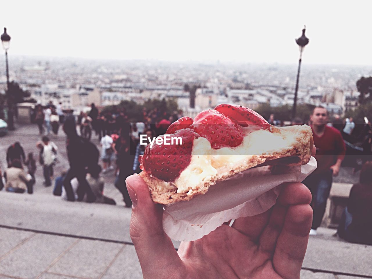 Cropped image of hand holding strawberry cake