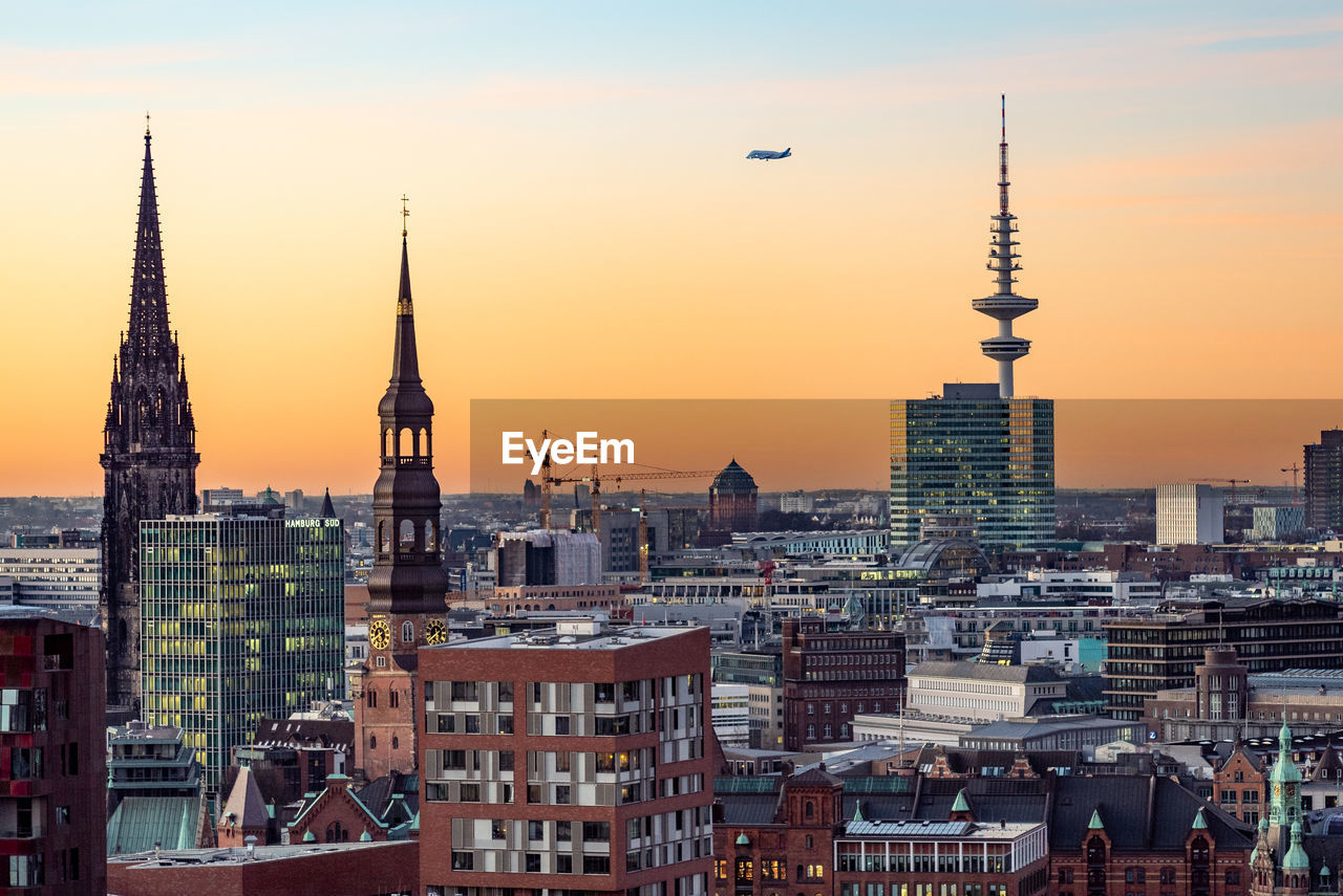 Buildings in city against sky during sunset