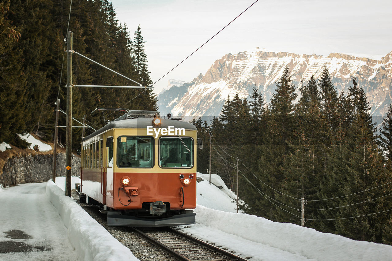 TRAIN ON RAILROAD TRACK AGAINST MOUNTAIN