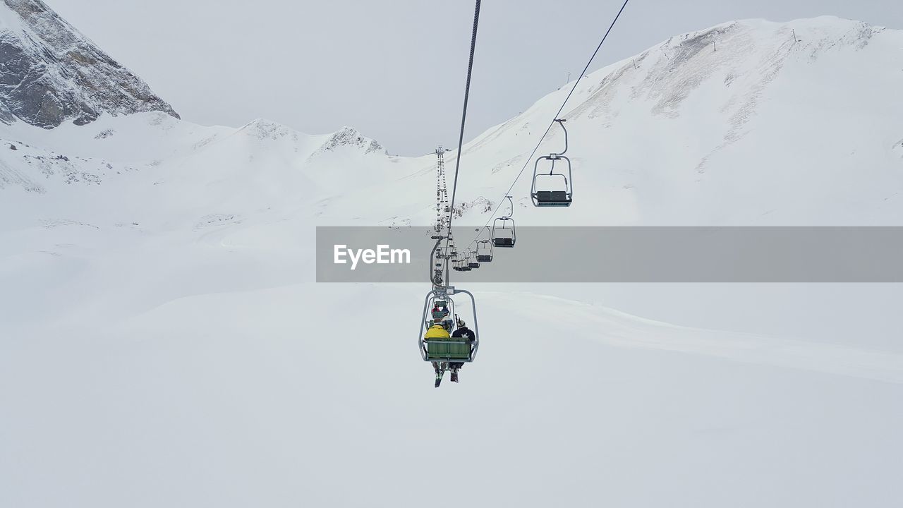 Overhead cable cars over snowy field during winter