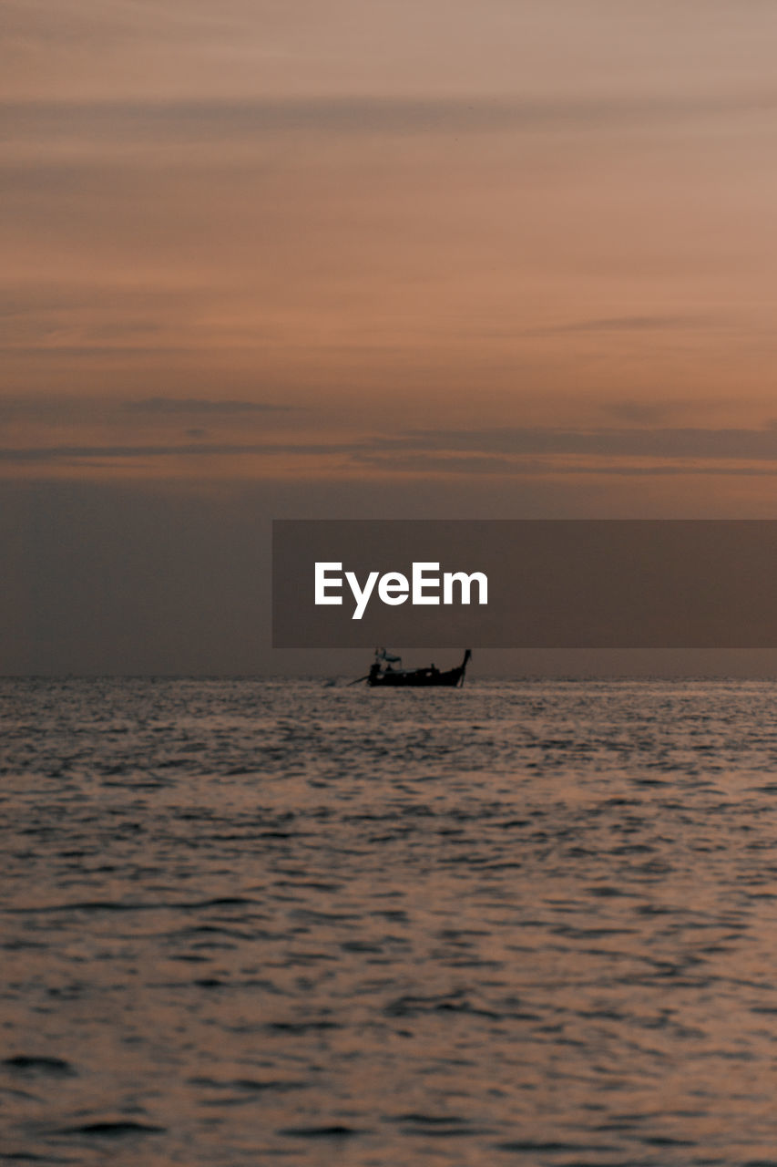 Fishing boat going out at sunset in thailand