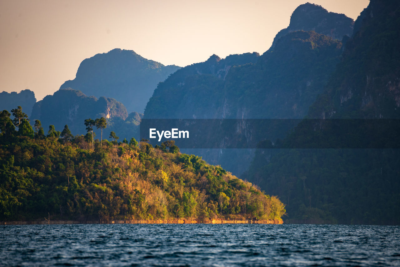 SCENIC VIEW OF SEA BY MOUNTAINS AGAINST SKY