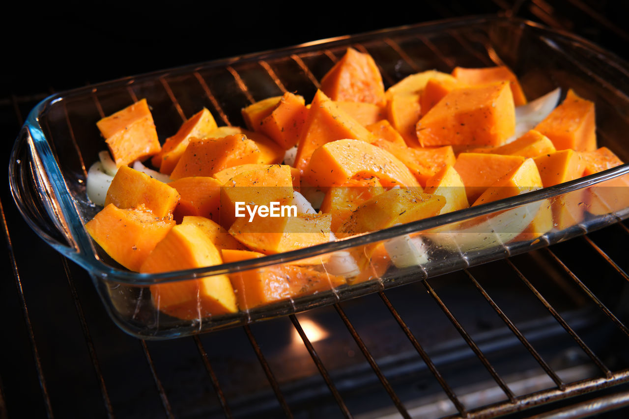 Cooking spicy pumpkin in an electric oven. pumpkin slices prepared for roasting in a baking sheet.