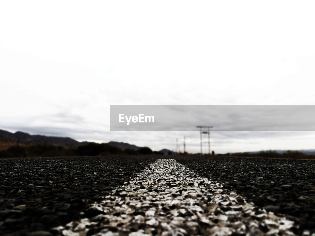 SURFACE LEVEL OF ROAD AMIDST FIELD AGAINST SKY