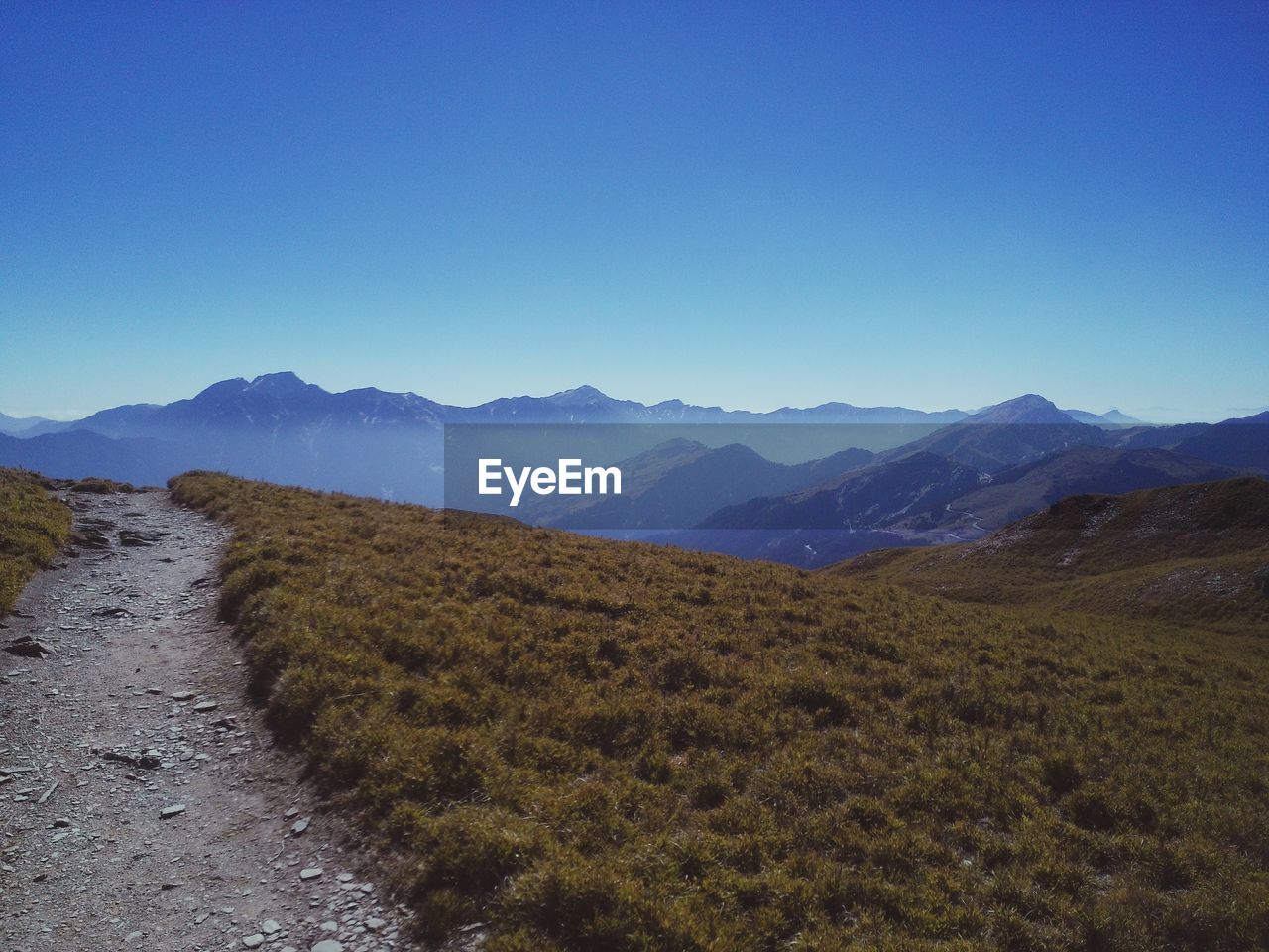 Scenic view of mountains against clear blue sky