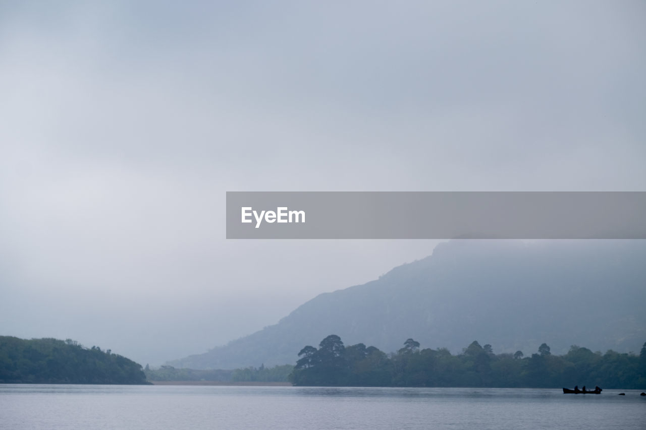 SCENIC VIEW OF LAKE BY MOUNTAIN AGAINST SKY