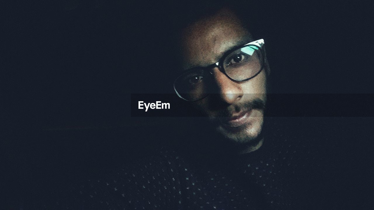 CLOSE-UP PORTRAIT OF YOUNG MAN WITH BLACK BACKGROUND