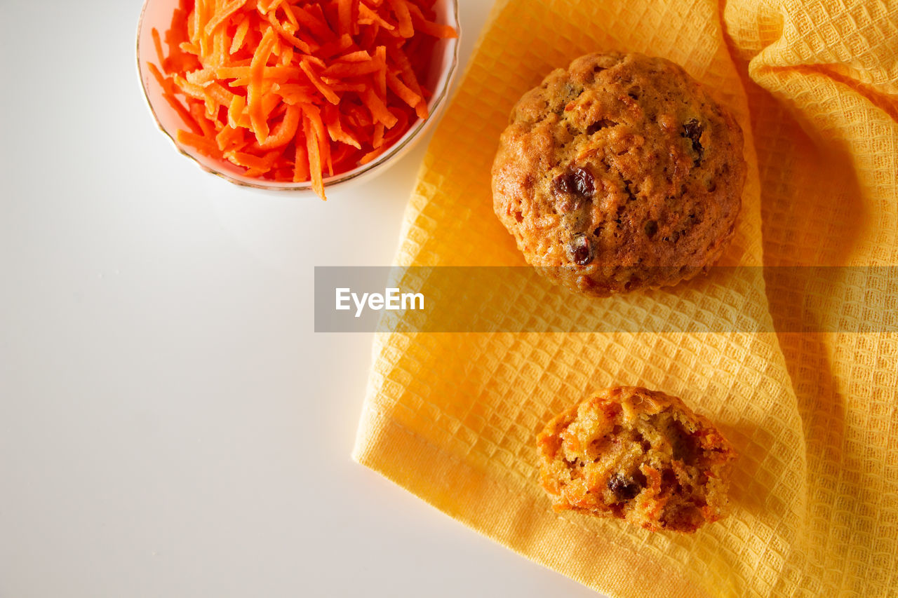 Tasty carrot muffins on a white background. homemade cakes on a yellow napkin. place for text