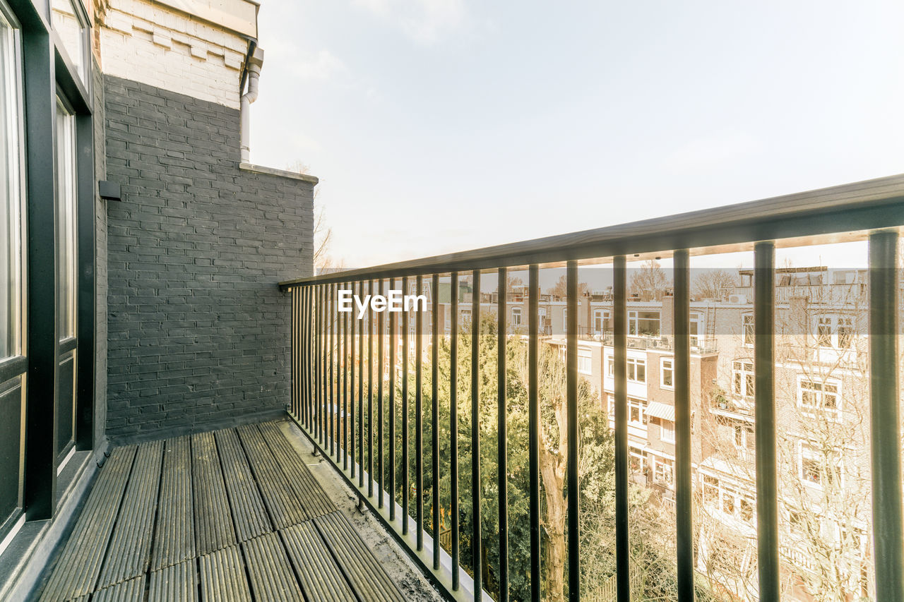 Part of balcony with metal railing in residential apartment building on sunny day