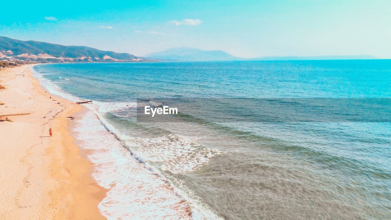 Scenic drone view of beach against sky