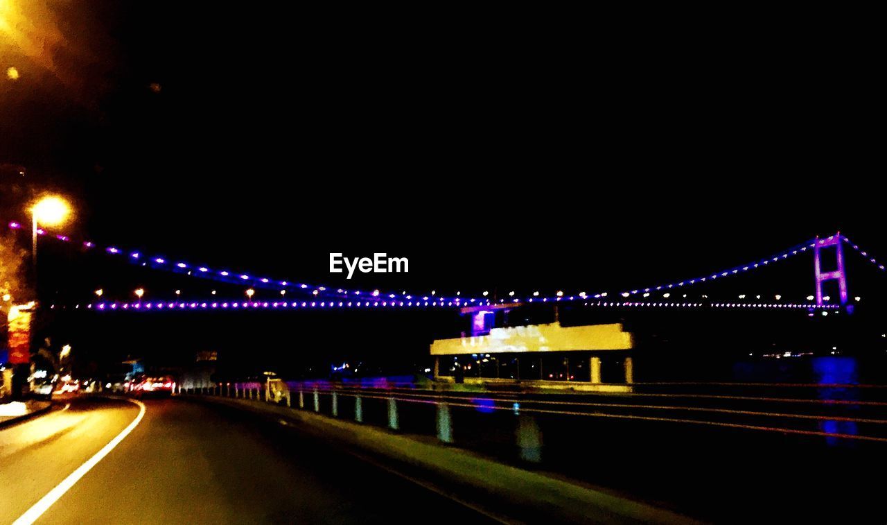 LIGHT TRAILS ON BRIDGE AT NIGHT