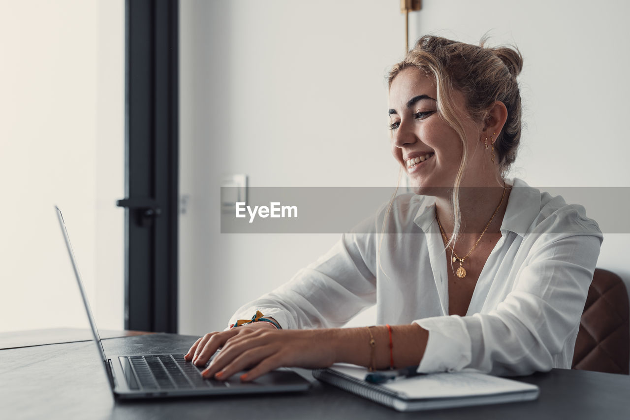 young woman using laptop while sitting at home