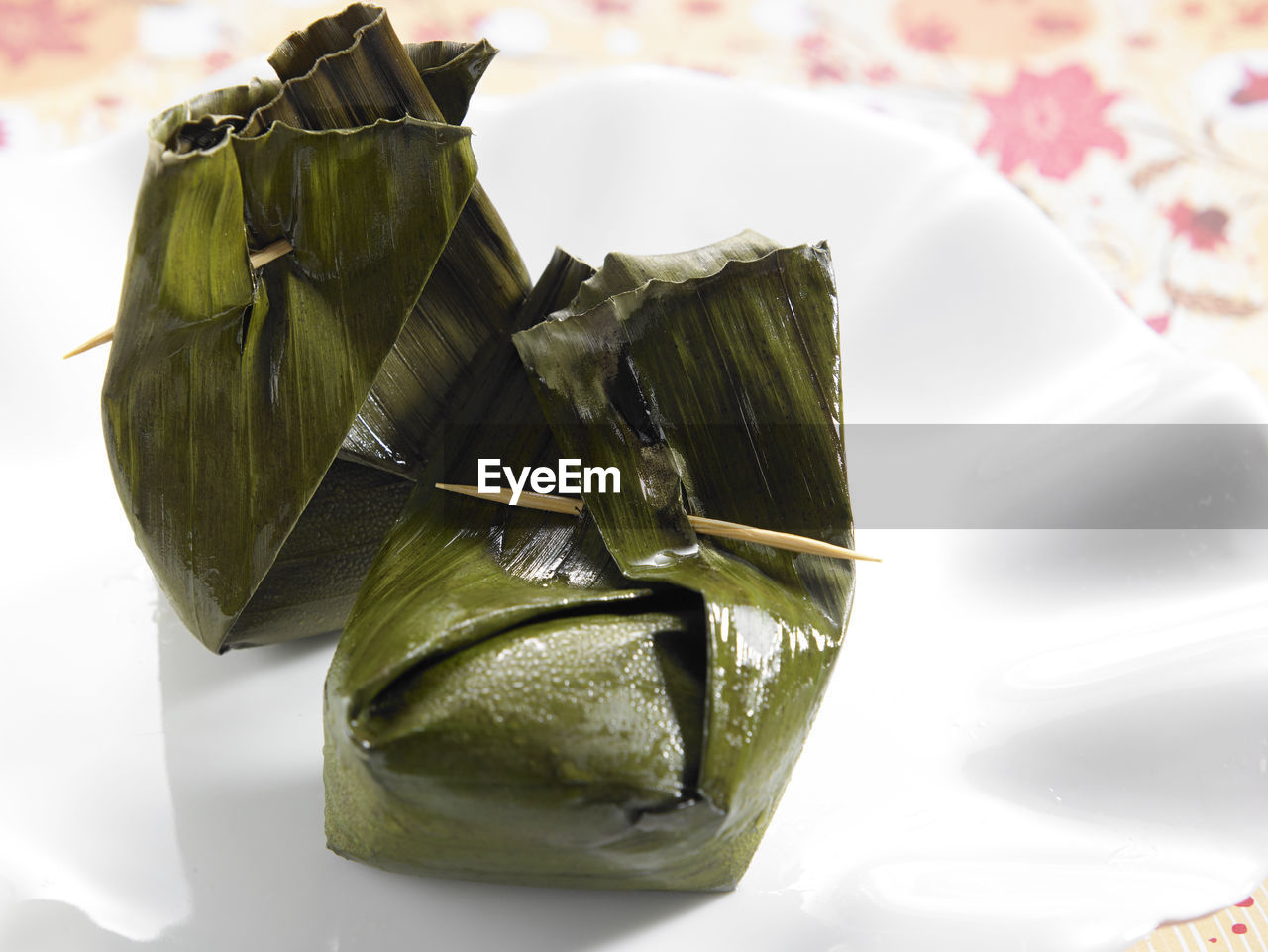 Close-up of food wrapped in banana leaves served in plate