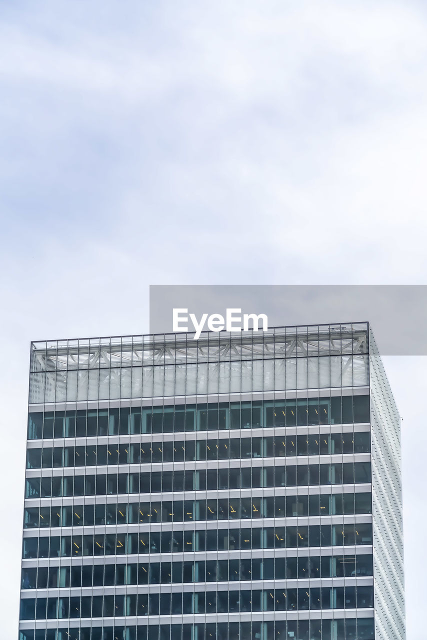 LOW ANGLE VIEW OF GLASS BUILDING AGAINST SKY