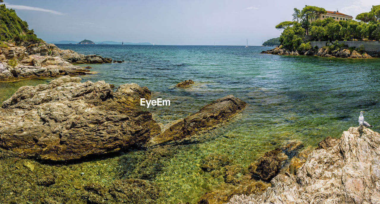 SCENIC VIEW OF ROCKS ON BEACH AGAINST SKY