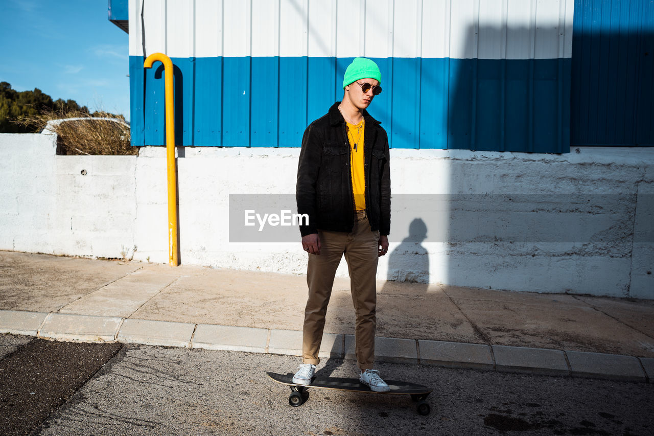 Full length of of man standing against wall outdoors