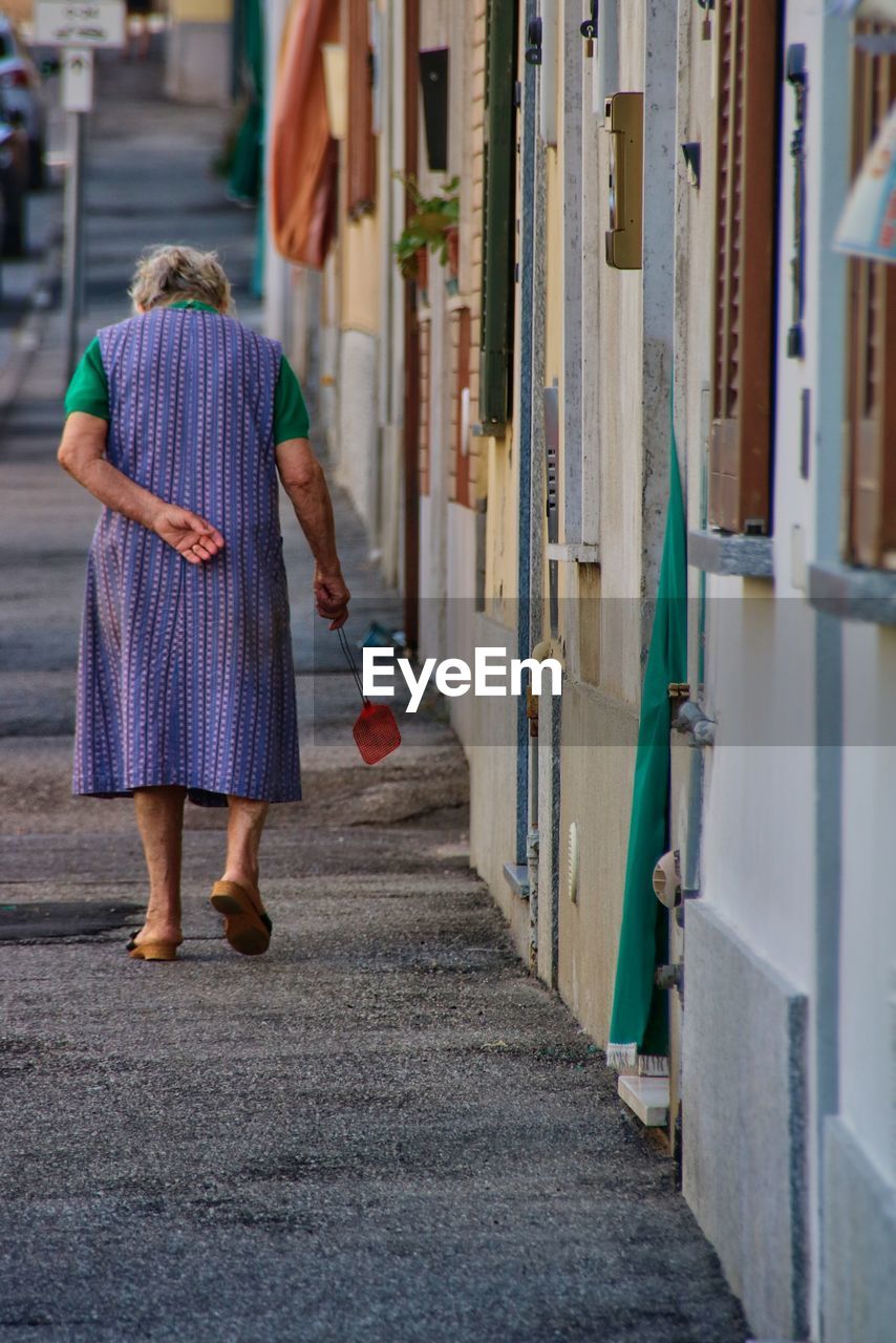 Rear view of senior woman walking on street
