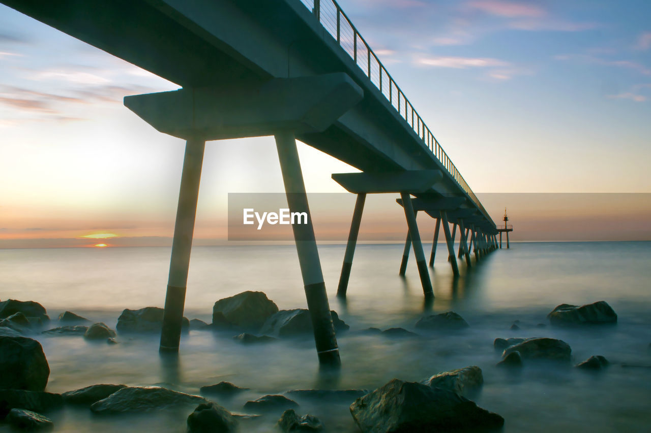 Close-up of beach against sky during sunset