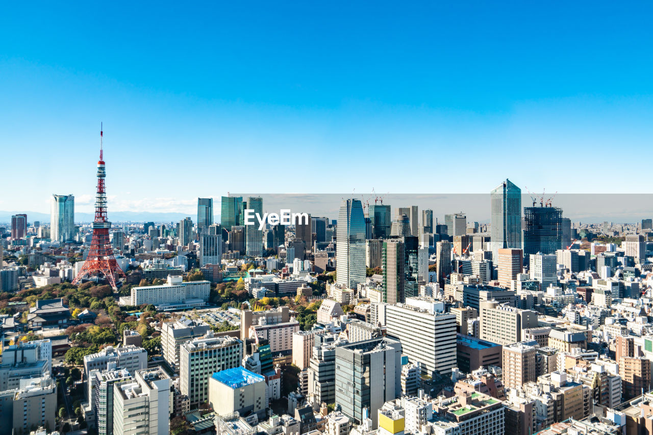 Aerial view of city buildings against blue sky