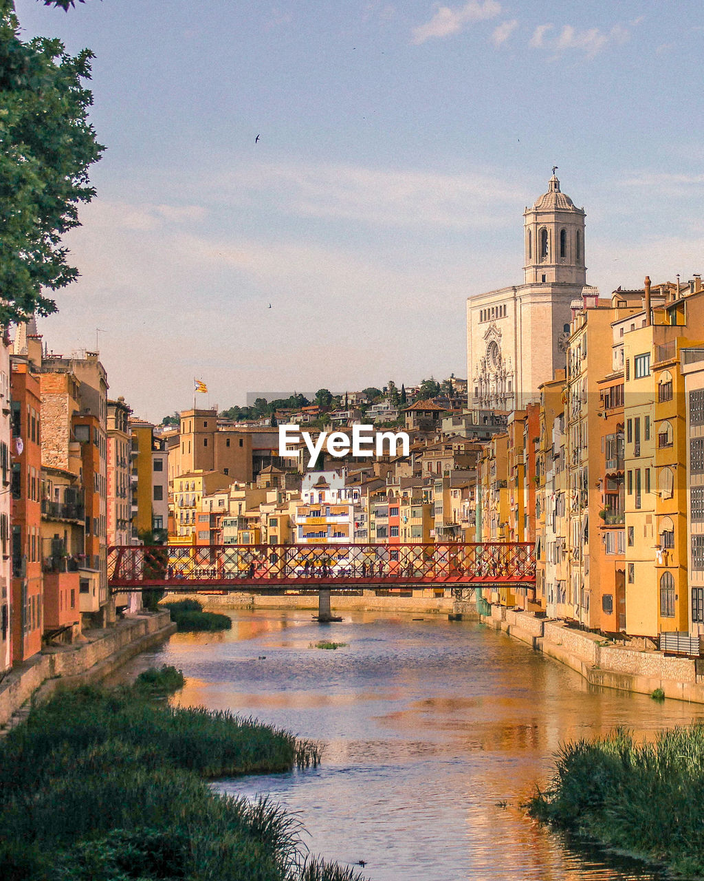 Buildings by river against sky in city