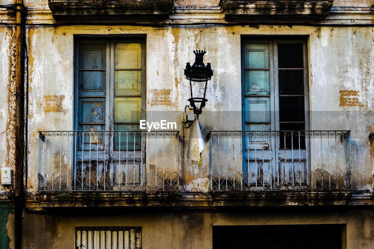 urban area, architecture, building exterior, built structure, window, facade, old, no people, house, building, street, road, day, wall, lighting equipment, residential district, outdoors, history, city, the past, weathered, ancient history, low angle view, abandoned, street light