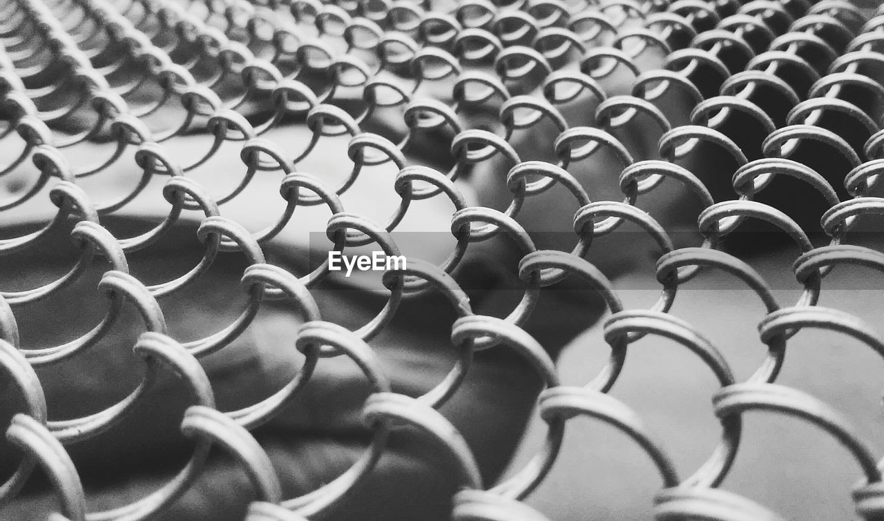 Thoughtful man seen through chainlink fence