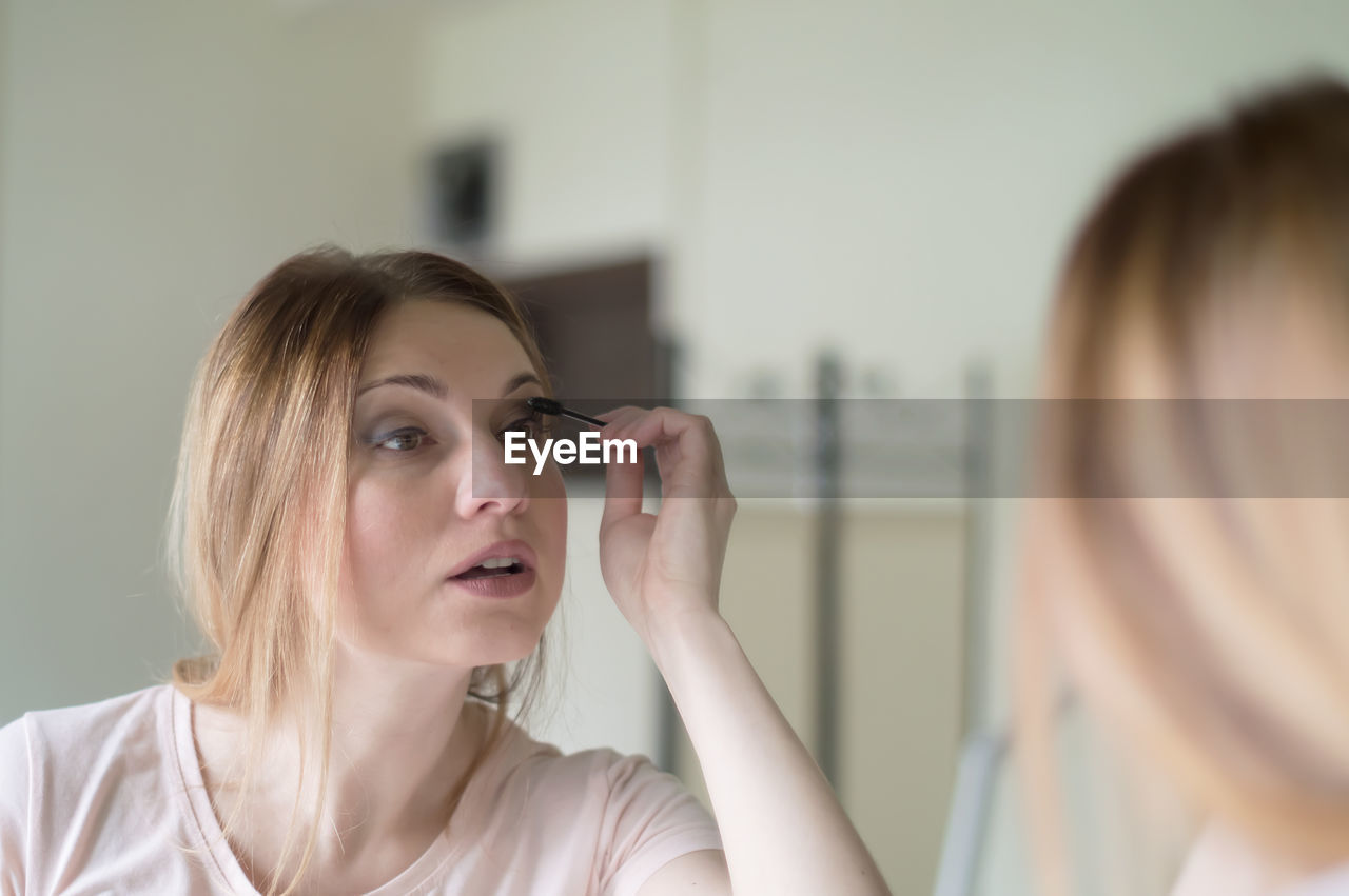 Close-up of woman applying mascara