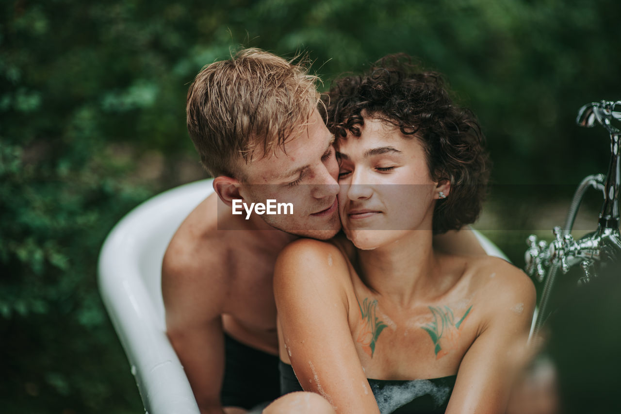 Portrait of young couple kissing outdoors