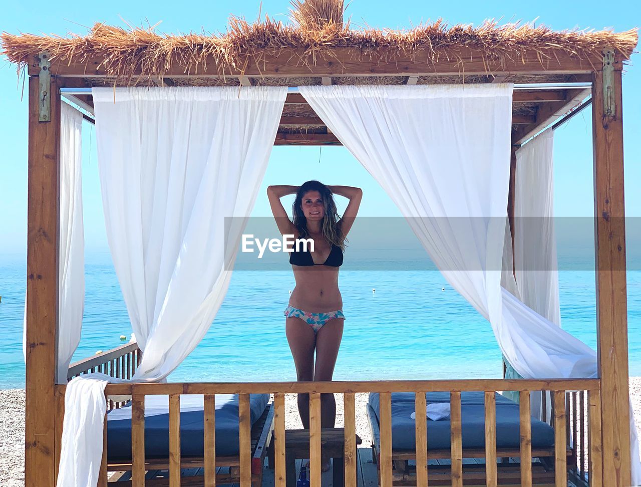 Portrait of woman standing in gazebo at beach