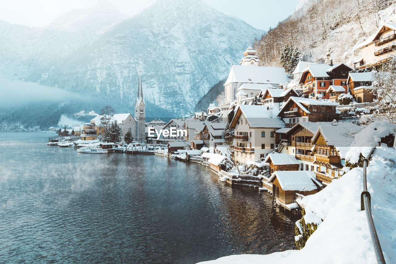 Snow covered townscape by lake