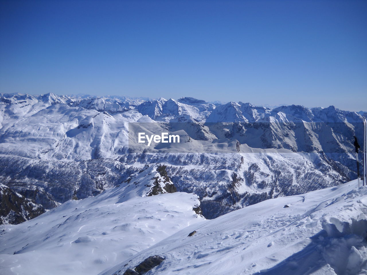 Scenic view of snowcapped mountains against clear blue sky