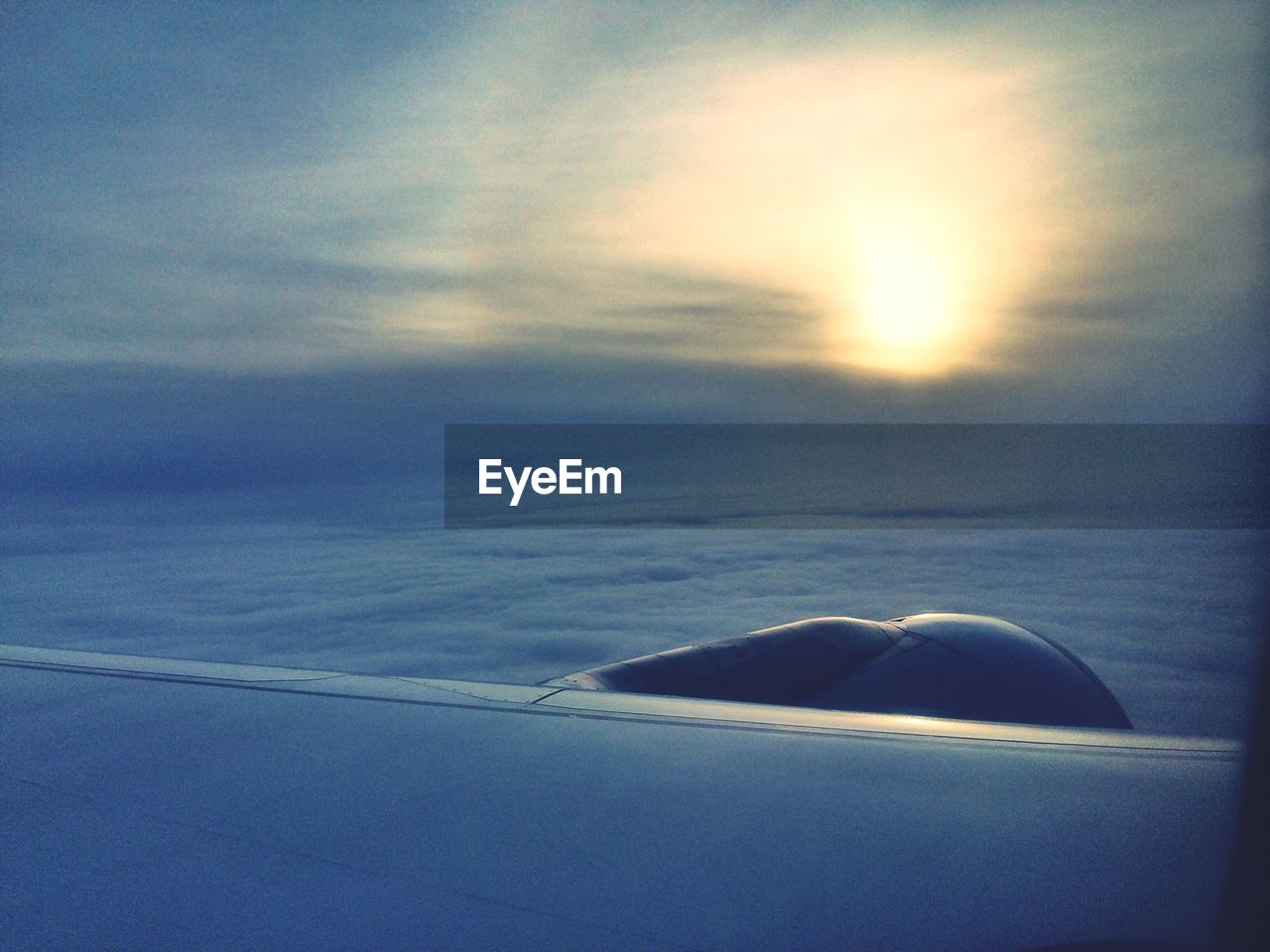 Wing of flying aircraft at sunset