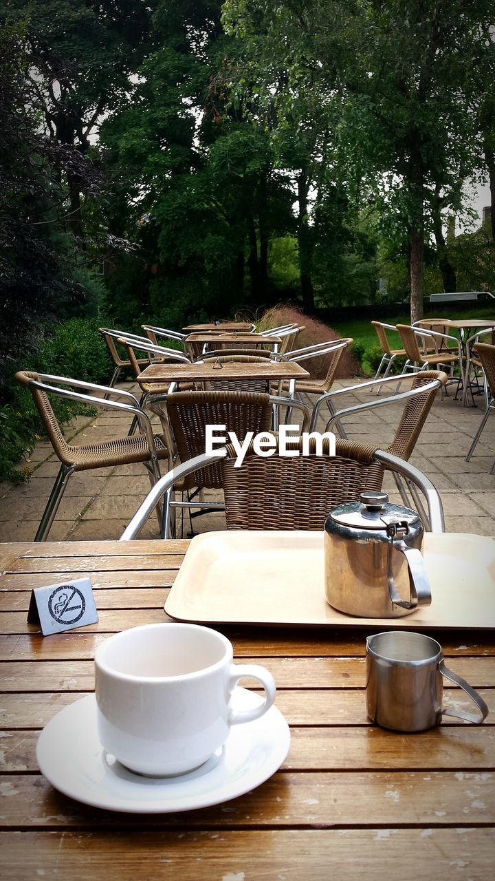 COFFEE CUP WITH COFFEE CUP ON WOODEN TABLE