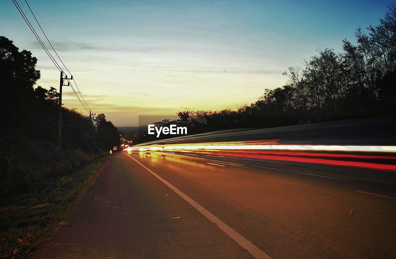 Traffic on road at sunset