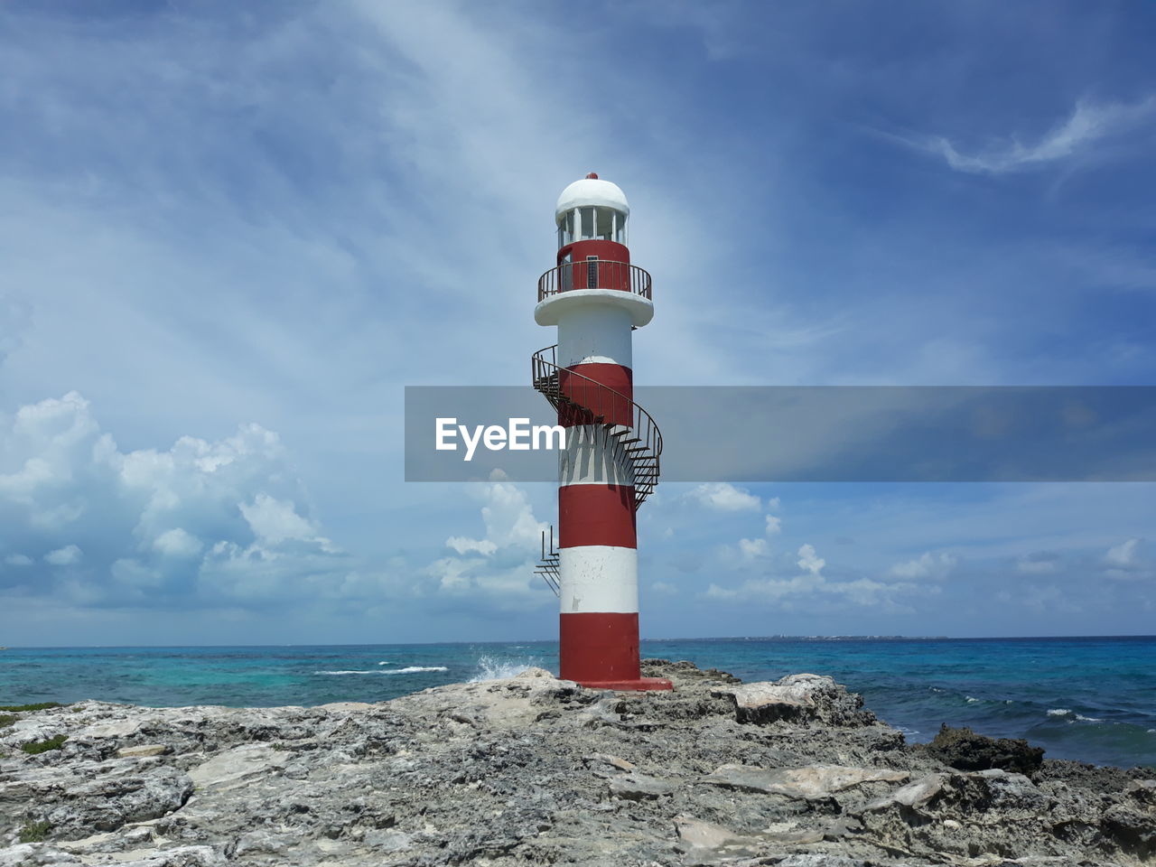 LIGHTHOUSE AMIDST SEA AGAINST SKY