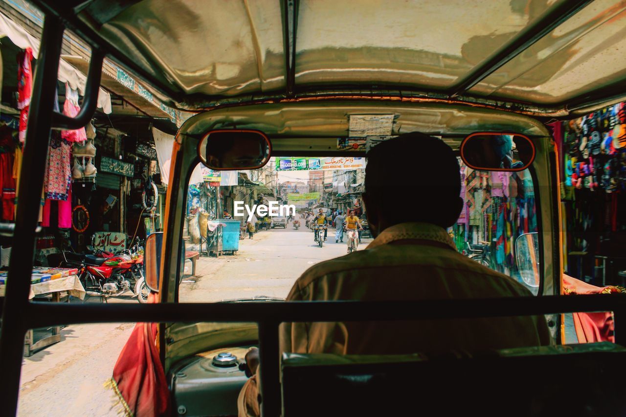 Rear view of driver driving rickshaw