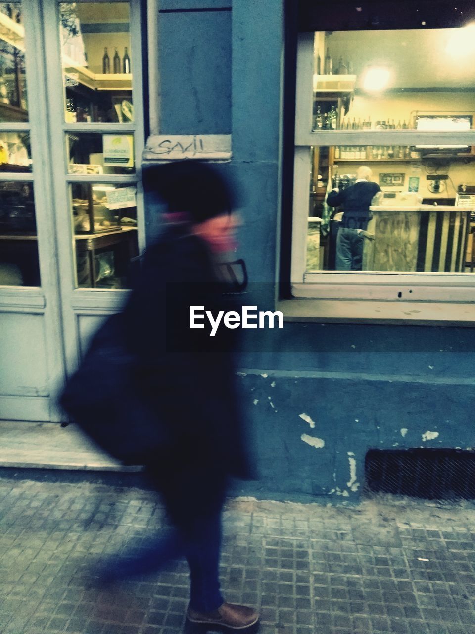 Blurred motion of woman walking on footpath