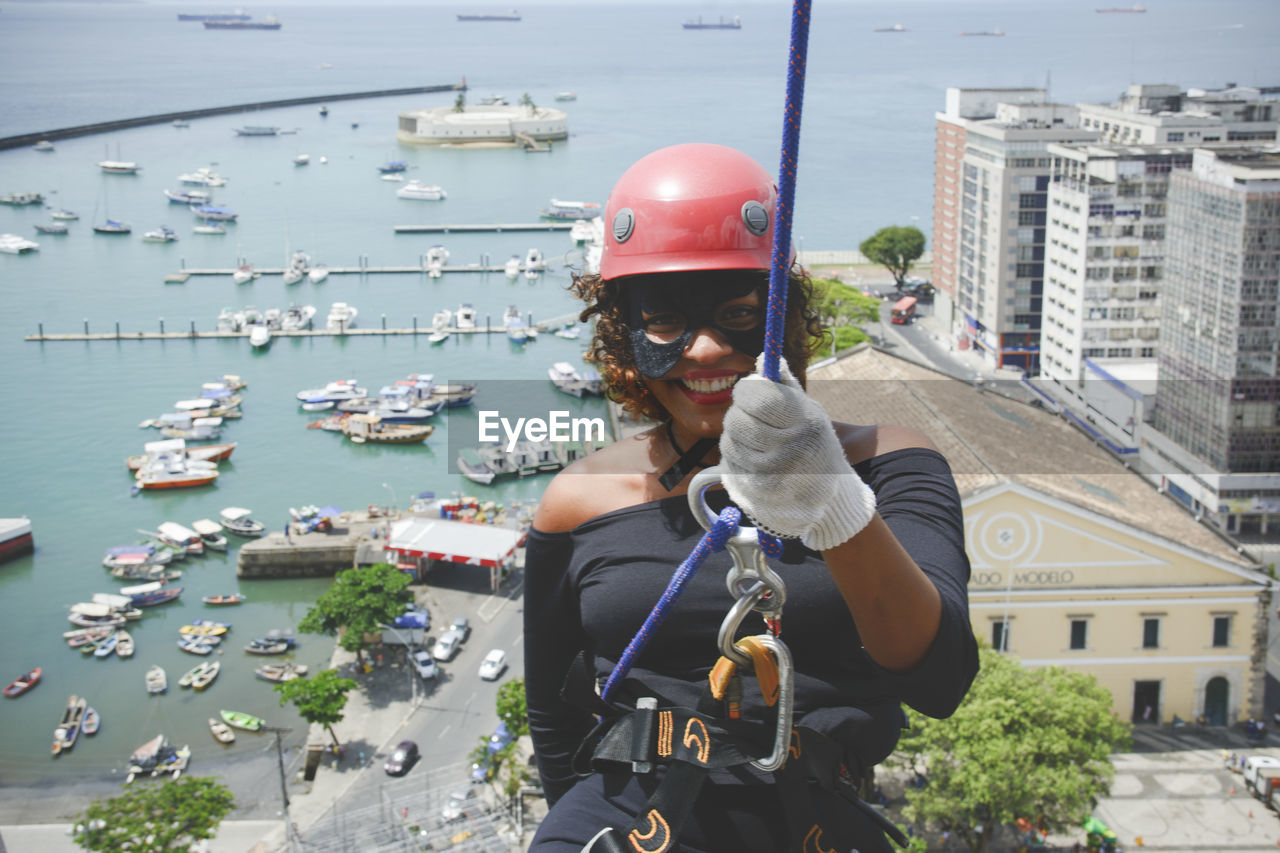 A woman dressed as a hero with a protective helmet holding the rappel rope.