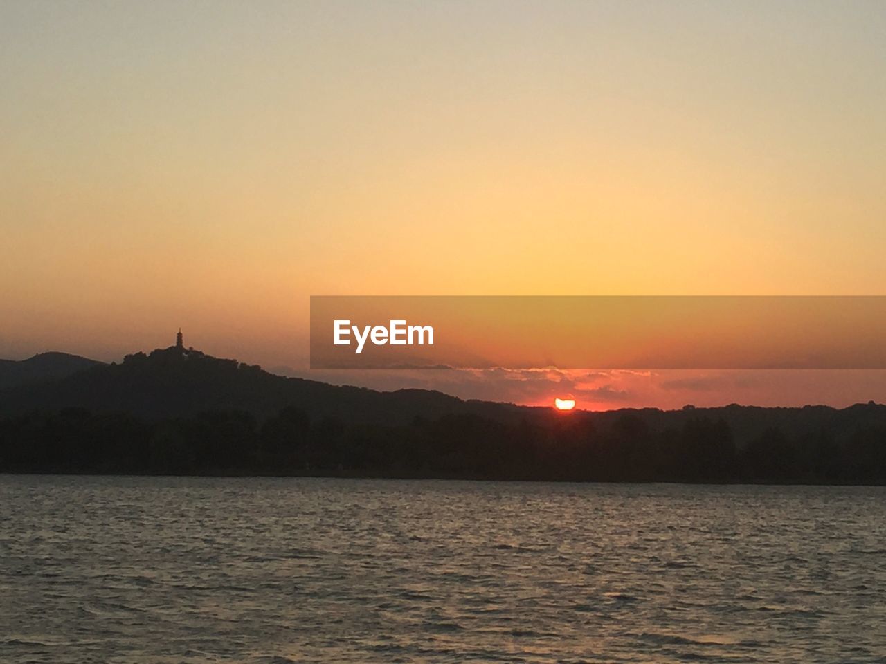 SCENIC VIEW OF SEA AND SILHOUETTE MOUNTAINS AGAINST SKY DURING SUNSET