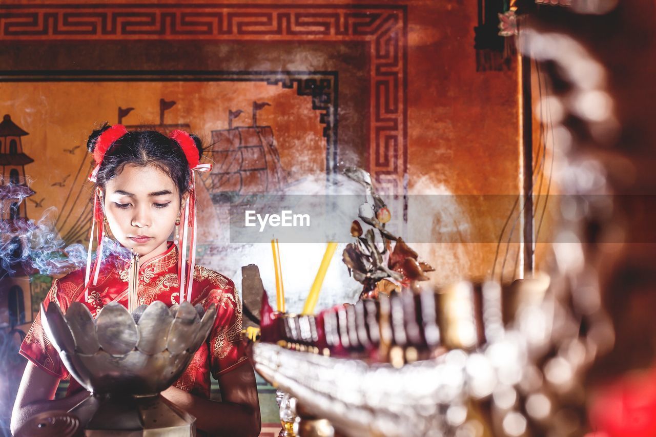 Teenage girl praying at temple