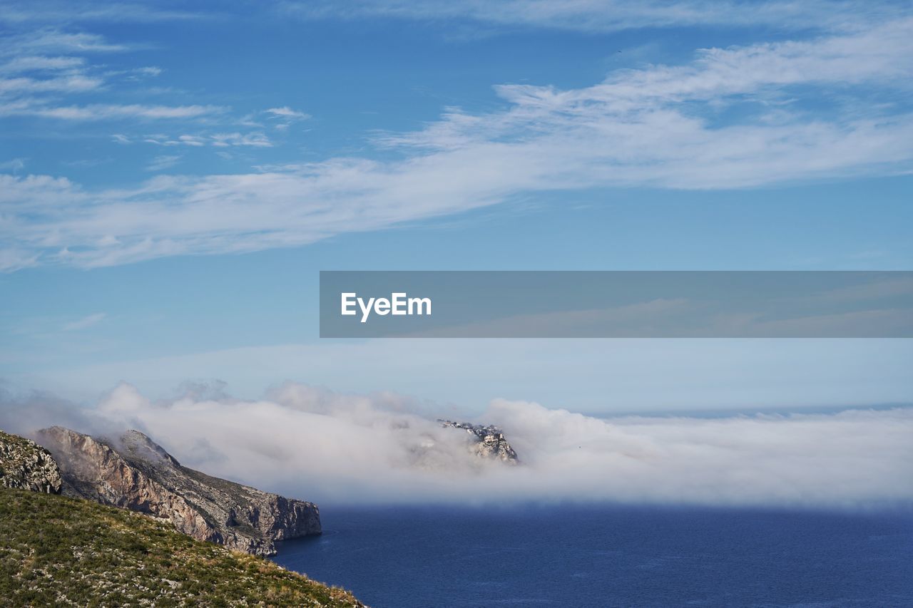 SCENIC VIEW OF SEA BY MOUNTAINS AGAINST SKY