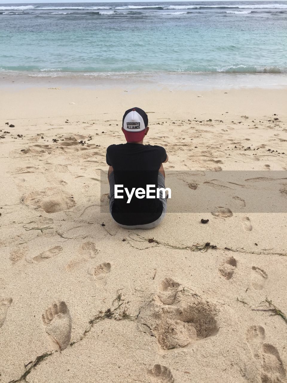 WOMAN SITTING ON BEACH