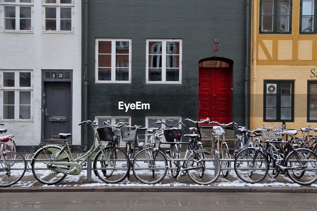 BICYCLES PARKED BY BUILDING