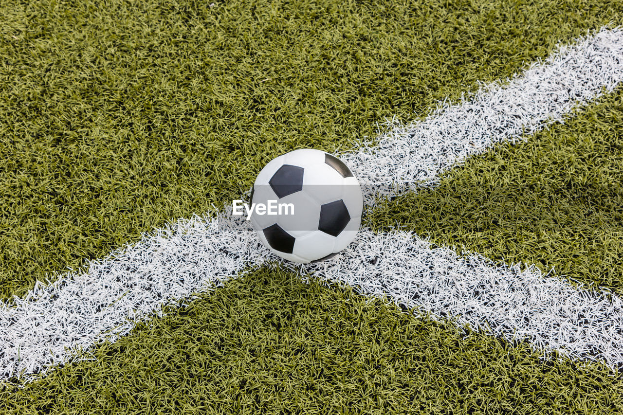 HIGH ANGLE VIEW OF SOCCER BALL ON FIELD BY WALL