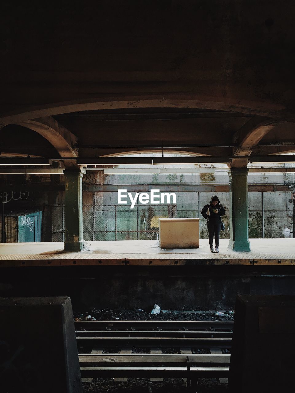 Person standing at railroad station platform