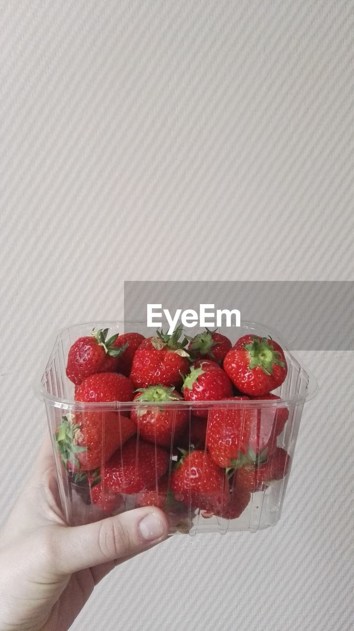 Close-up of hand holding strawberries