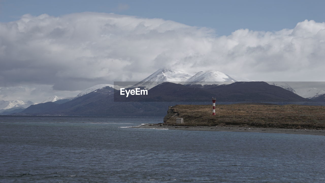 Scenic view of sea and mountains against sky