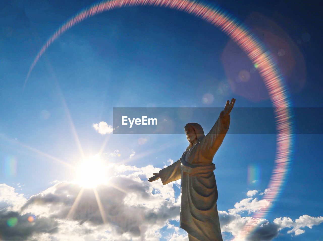 LOW ANGLE VIEW OF WOMAN STANDING IN THE SUN