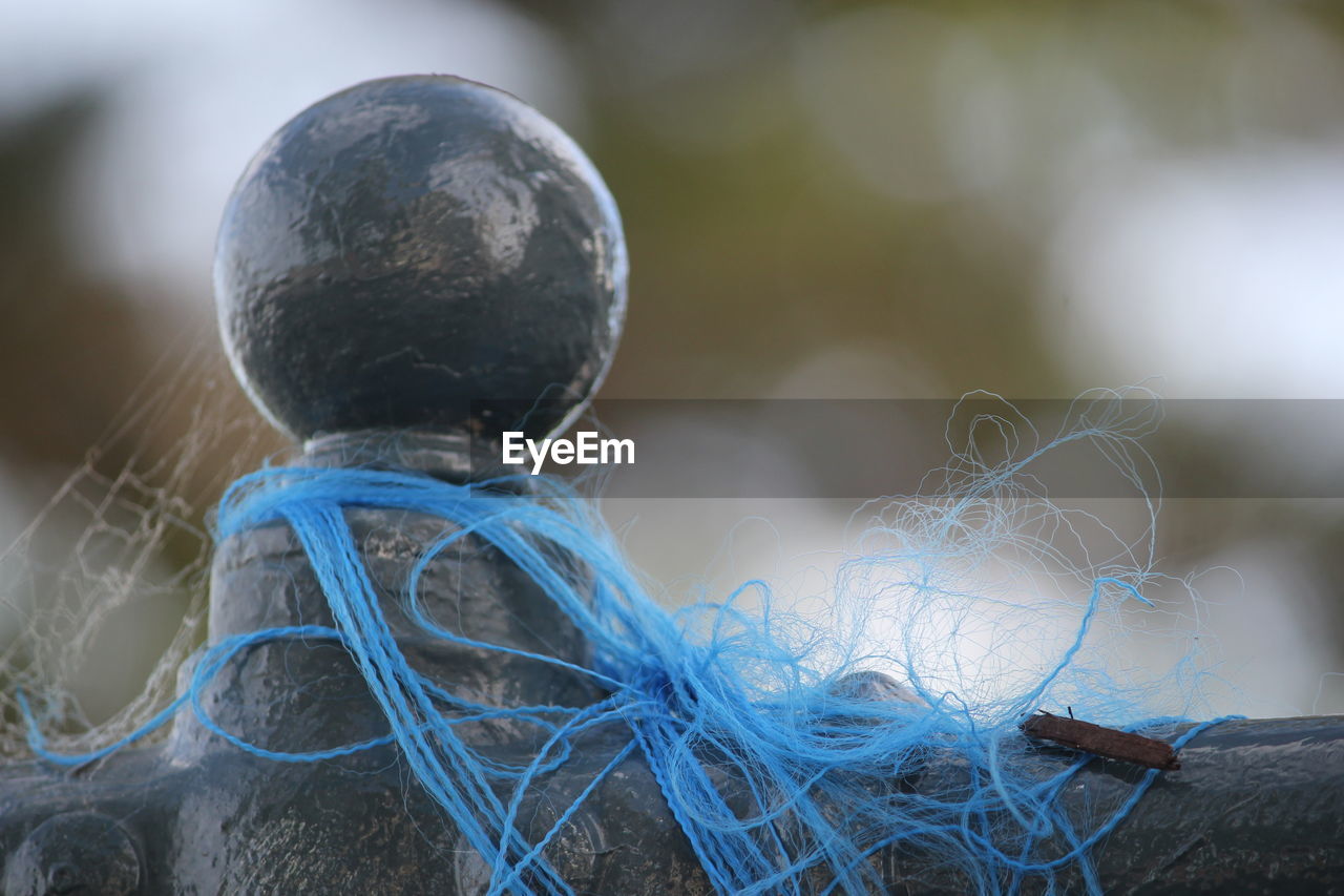 Close-up of blue yarn on railing